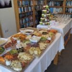 A delicious assortment of cheeses, appetisers, and cupcakes laid out in the library of a luxury holiday home