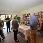 Guests gathered around a drinks table in the cosy library of a luxury holiday home