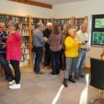 Guests enjoying a wine and cheese social event in the cosy library of a luxury holiday home