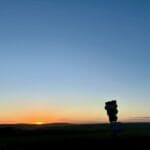 Sunrise over a countryside landscape with silhouetted road signs