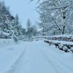 A snow-covered path winds through a wintery landscape