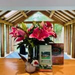 Vase of pink lilies on table.