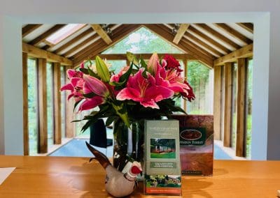 Vase of pink lilies on table.