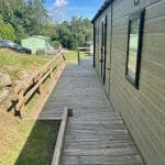 Wooden walkway leading to a holiday lodge at Warren Forest Park