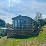 Modern holiday lodge with a wooden deck at Warren Forest Park