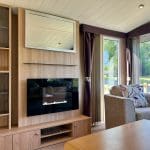 Modern lounge area with a sleek electric fireplace and scenic views at Warren Forest Park